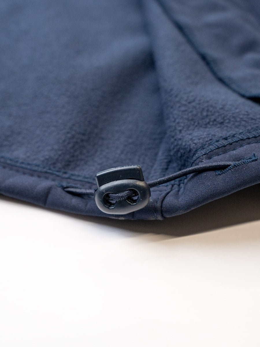 Dunkelblaue Softshell-Jacke mit Druckknopf am Saum, Detail der Verschlüsse