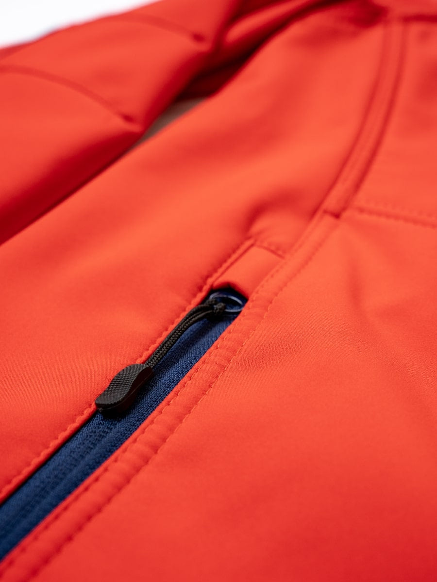 Softshelljacke Detail: Frontreißverschluss mit blauer Einfassung und roter Steppnaht