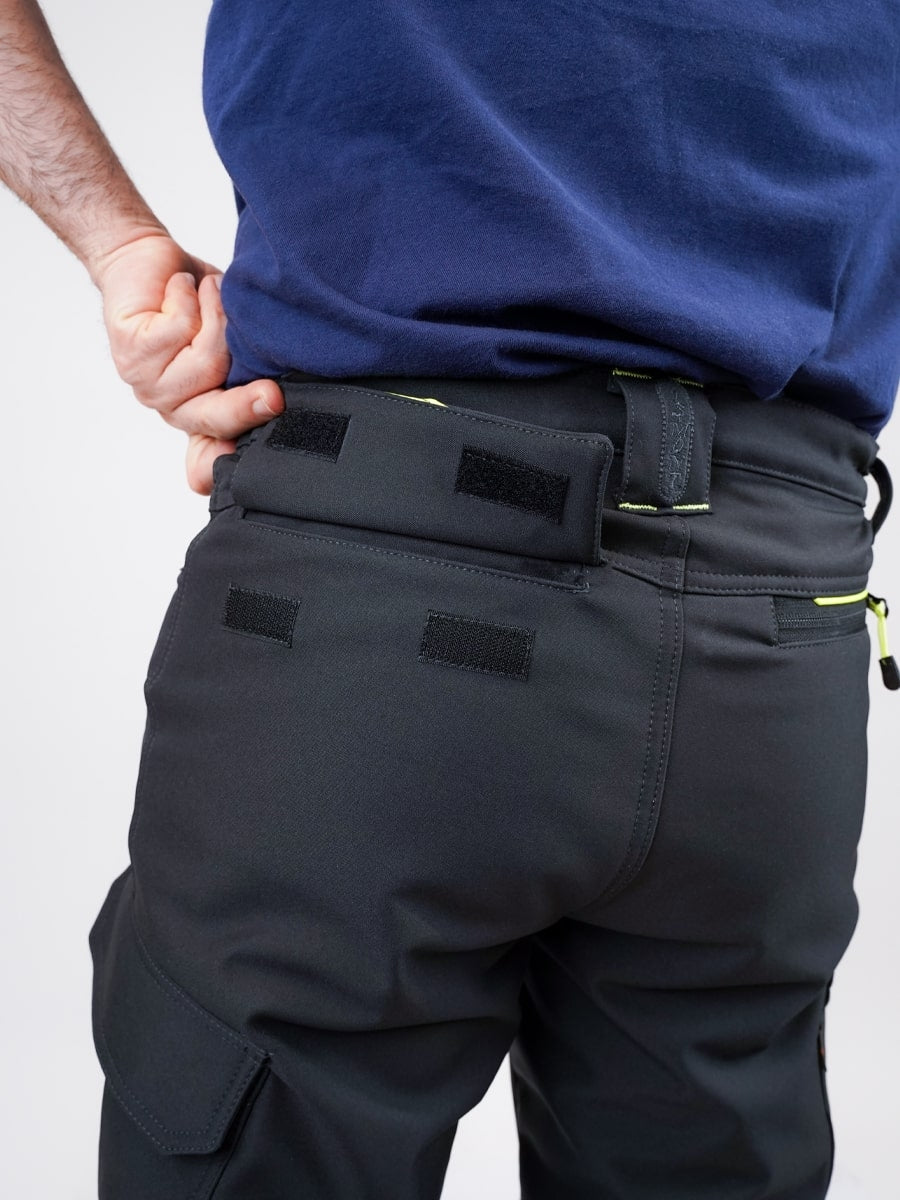 Dunkle Softshell-Bundhose am Bund mit Taschenklappen, verdecktem Verschluss und gelber Naht