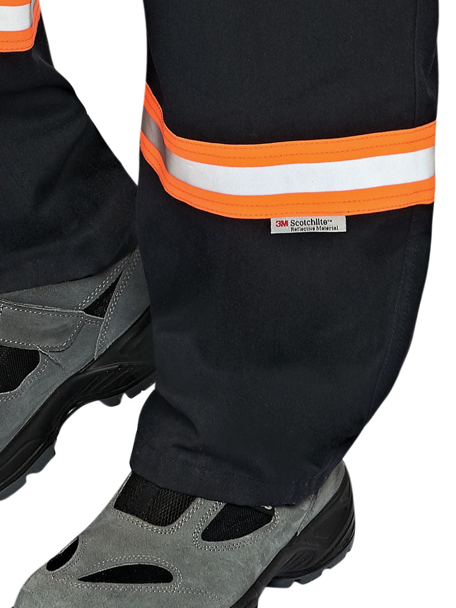 Flammhemmender Overall mit Reflexstreifen und Gesäßtasche; Stiefel sichtbar darunter.
