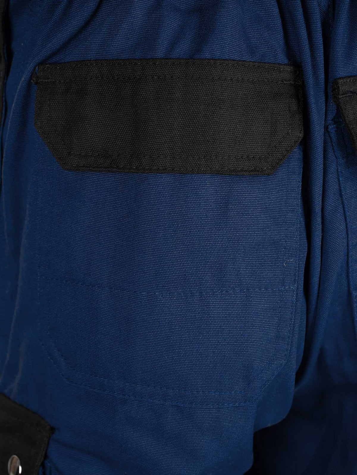 Seitentasche-Detail: marineblaue Arbeitshose mit schwarzem Mesh-Einsatz und Absteppung